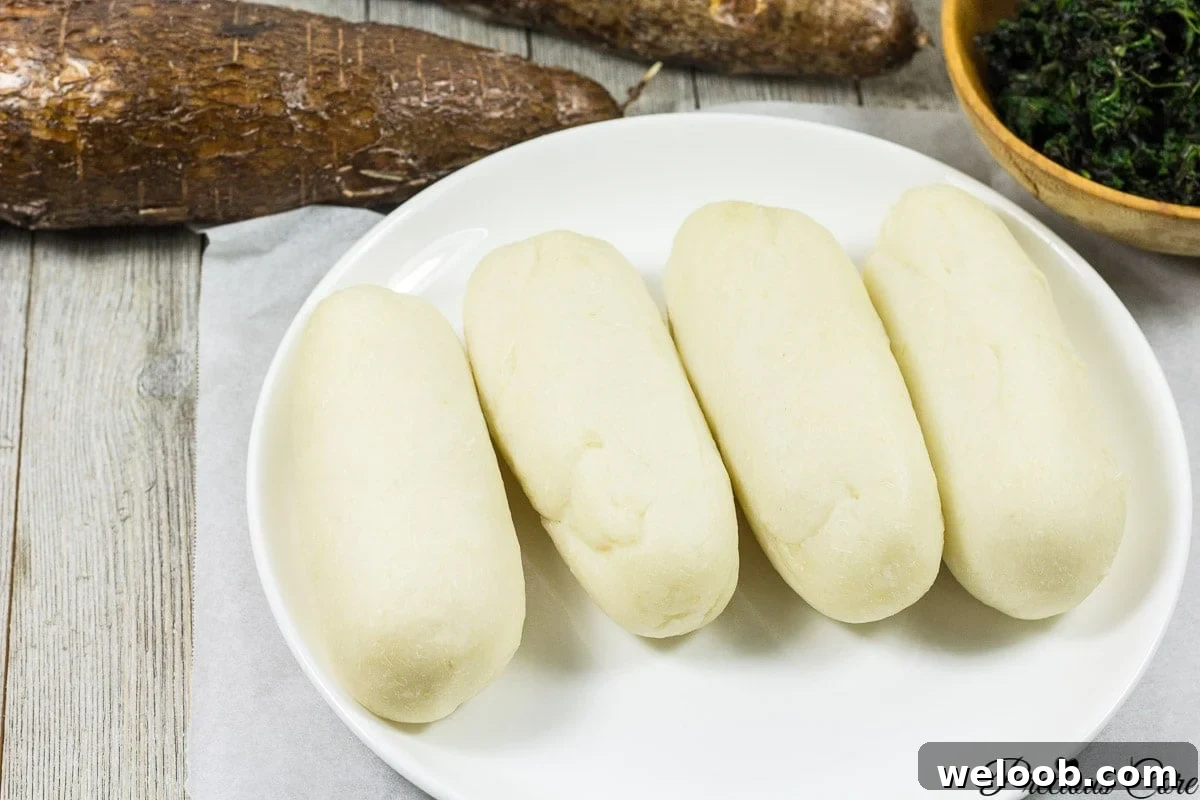 Water fufu or cassava fufu on a white plate.