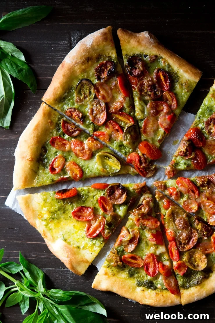 basil pesto pizza topped the cherry tomatoes and mozzarella cut into slices on a wooden board with basil 