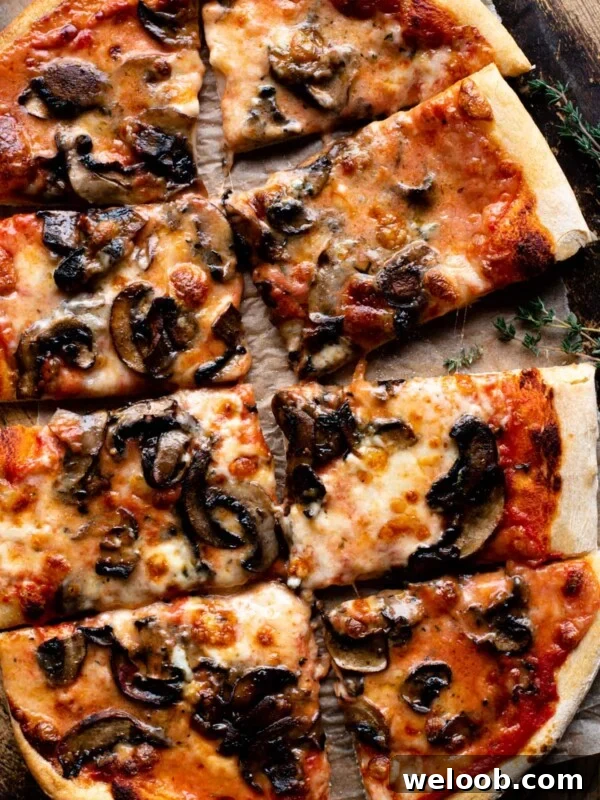 An overhead shot of a Taleggio and Mushroom Pizza cut into 8 slices.