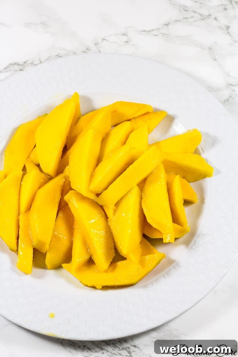 Sliced mango on a white plate.