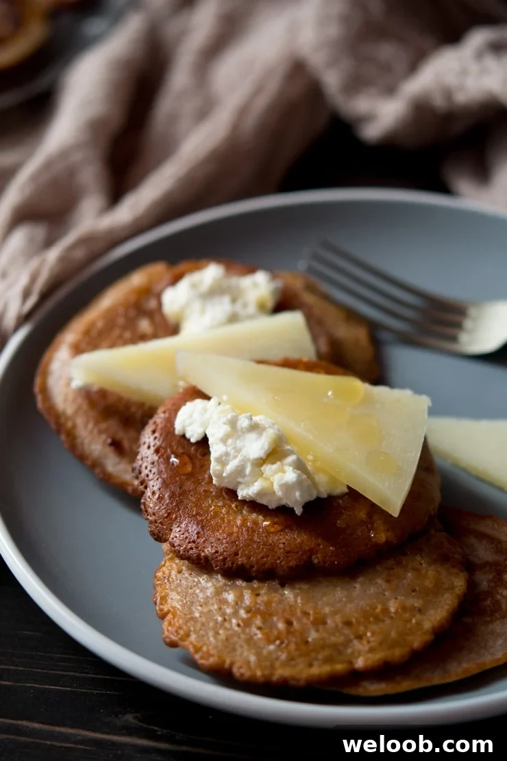 a close up of chestnut fritters topped with pecorino cheese, ricotta and honey