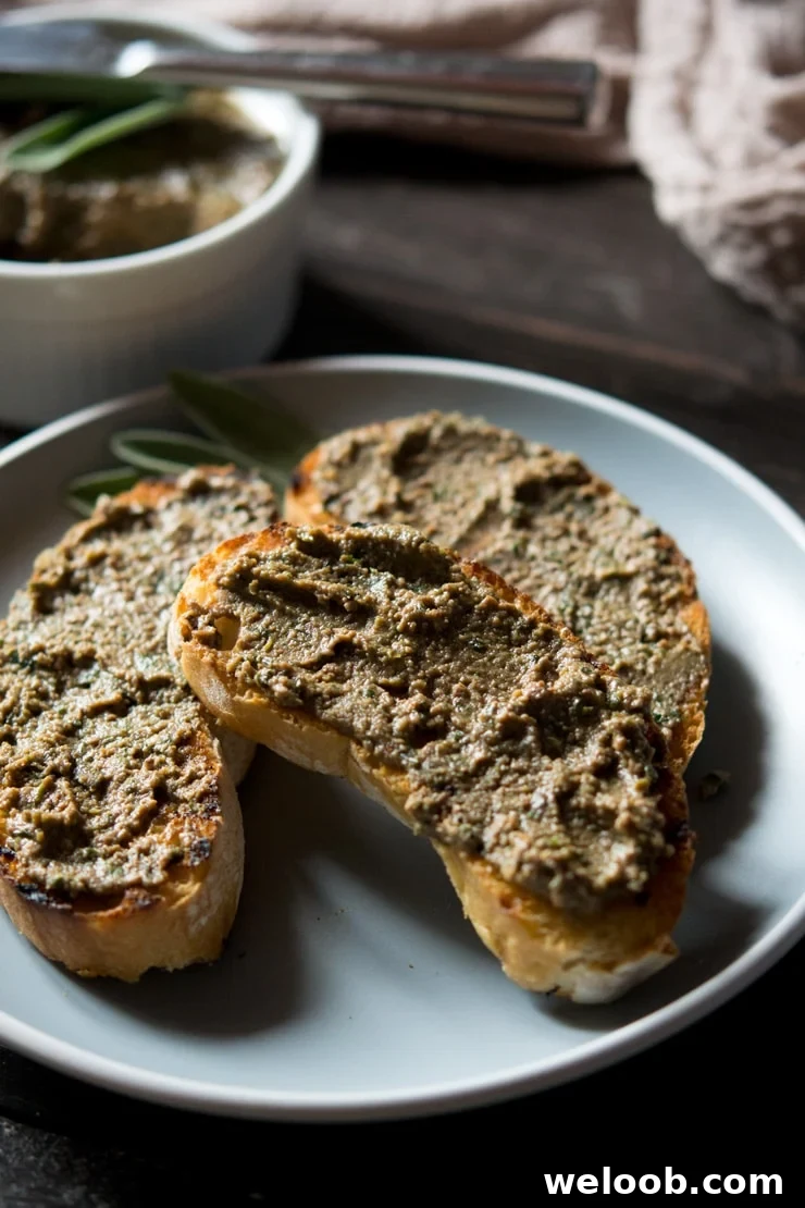 a close up of chicken liver pate spread on crusty bread