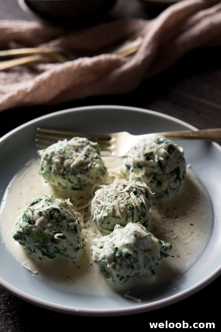 A close up of broccoli rabe and ricotta gnudi in a parmesan cream