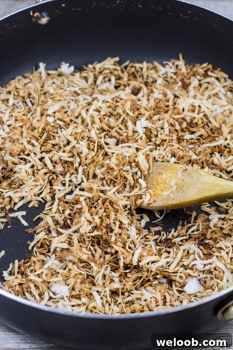 Spoon stirring coconut flakes.