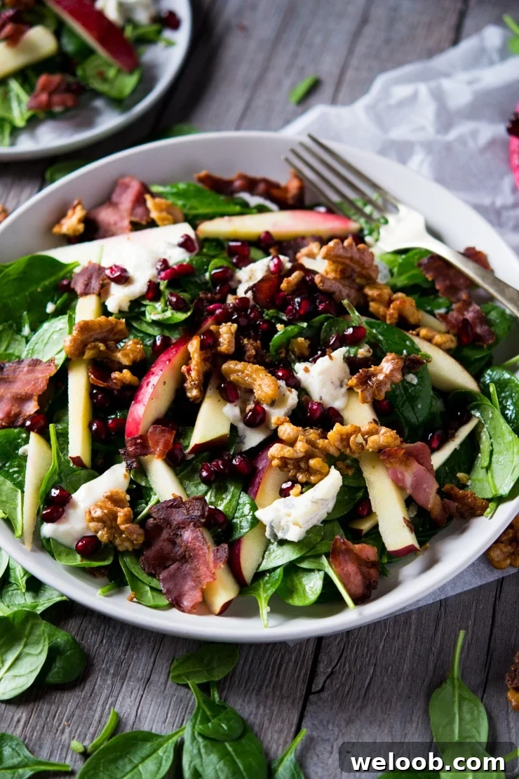 A winter salad served on a large plate on a wooden surface