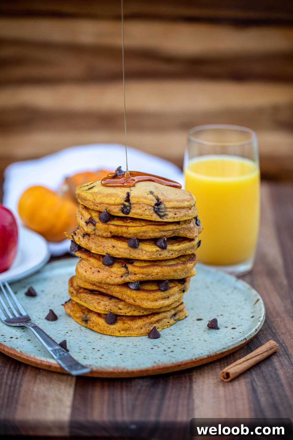 Stack of pancakes with honey drizzling on top.