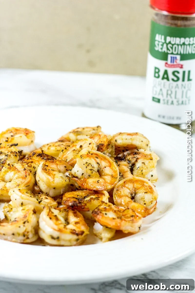 Shrimp pasta on a plate near a container of all-purpose seasoning.