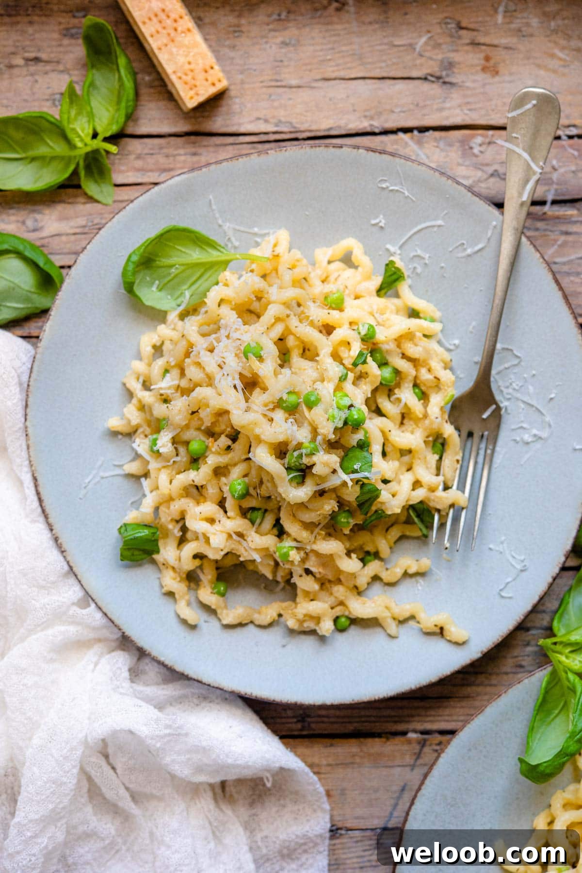 An overhead shot of artichoke pasta on a plate with basil
