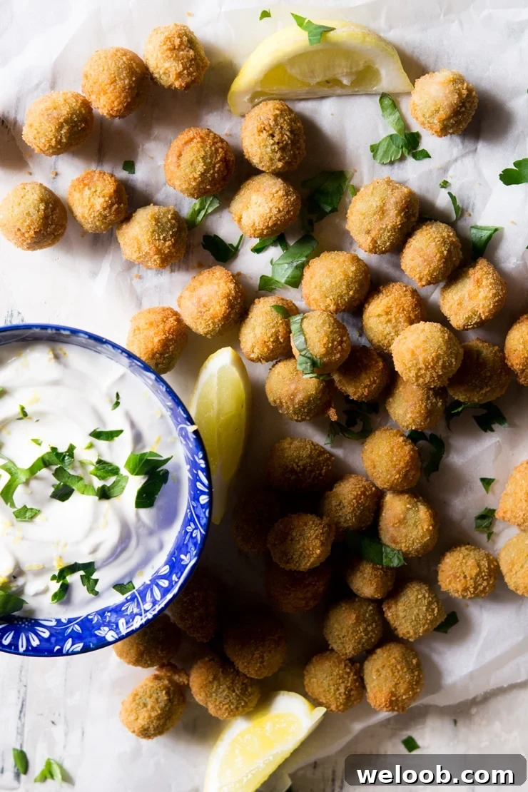 An overhead shot of fried stuffed olives and a sour cream dip