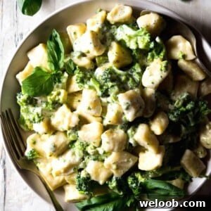 A close up of ricotta gnocchi with parmesan sauce on a plate