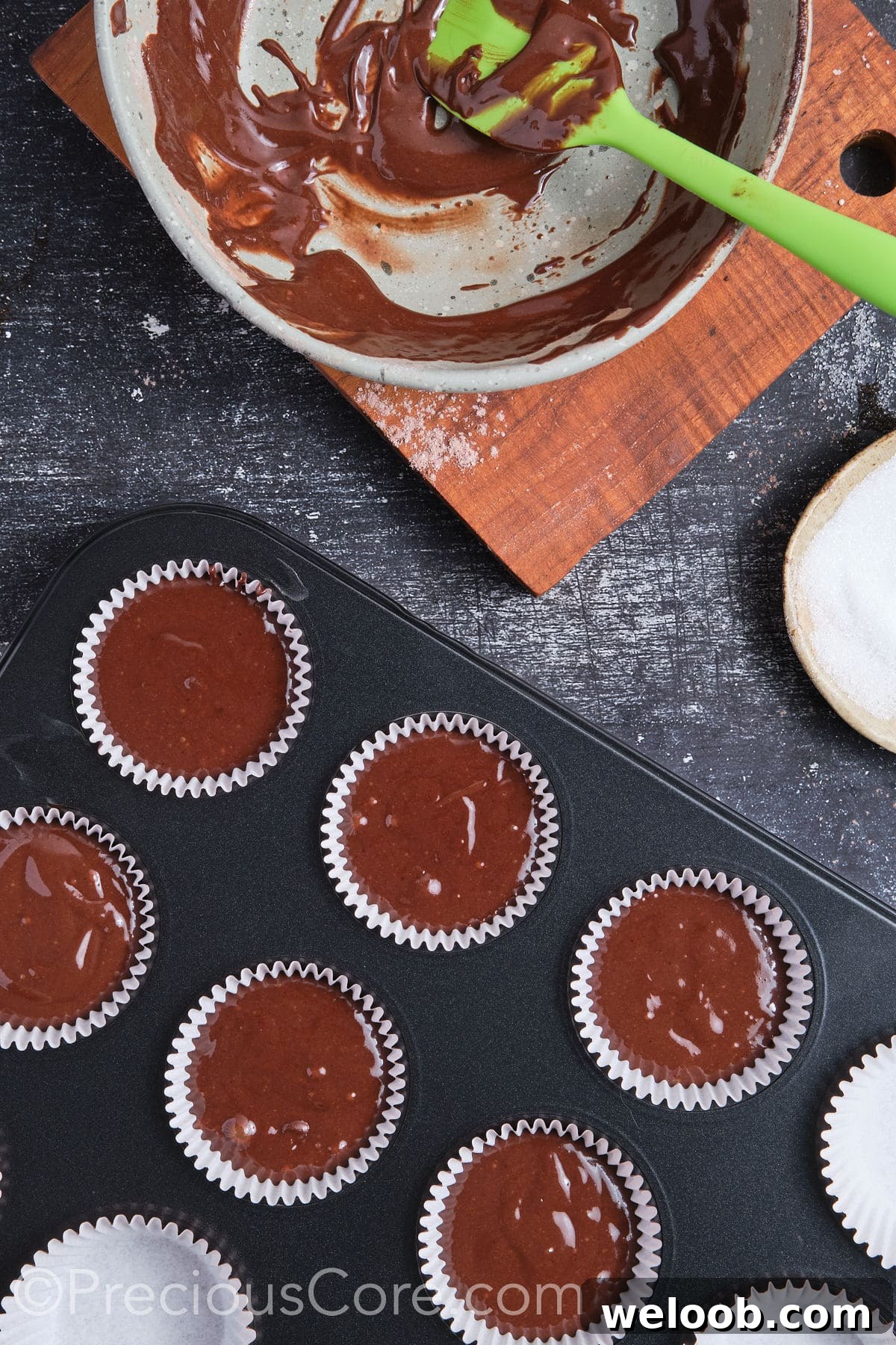 Chocolate cupcake batter in muffin pan ready for baking.
