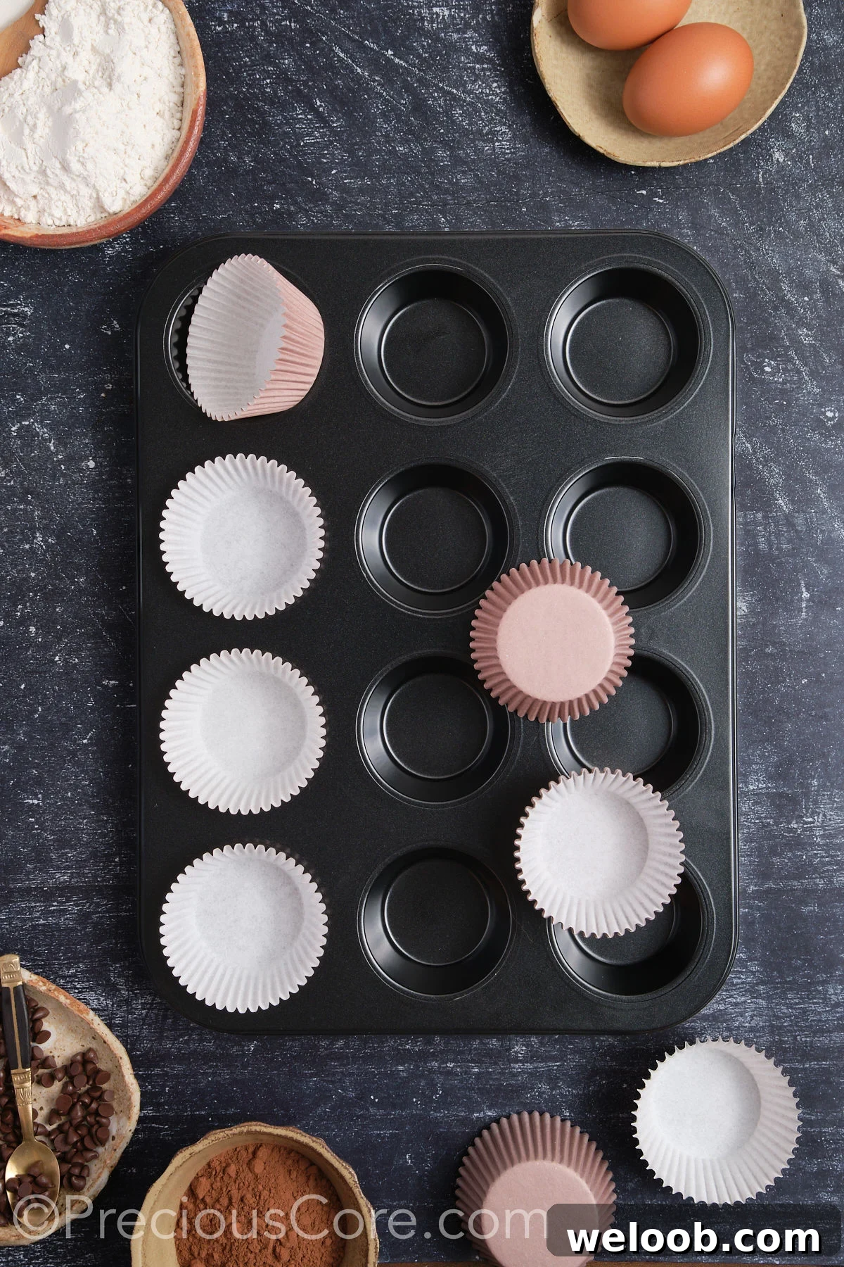 Lining a muffin pan with cupcake liners.