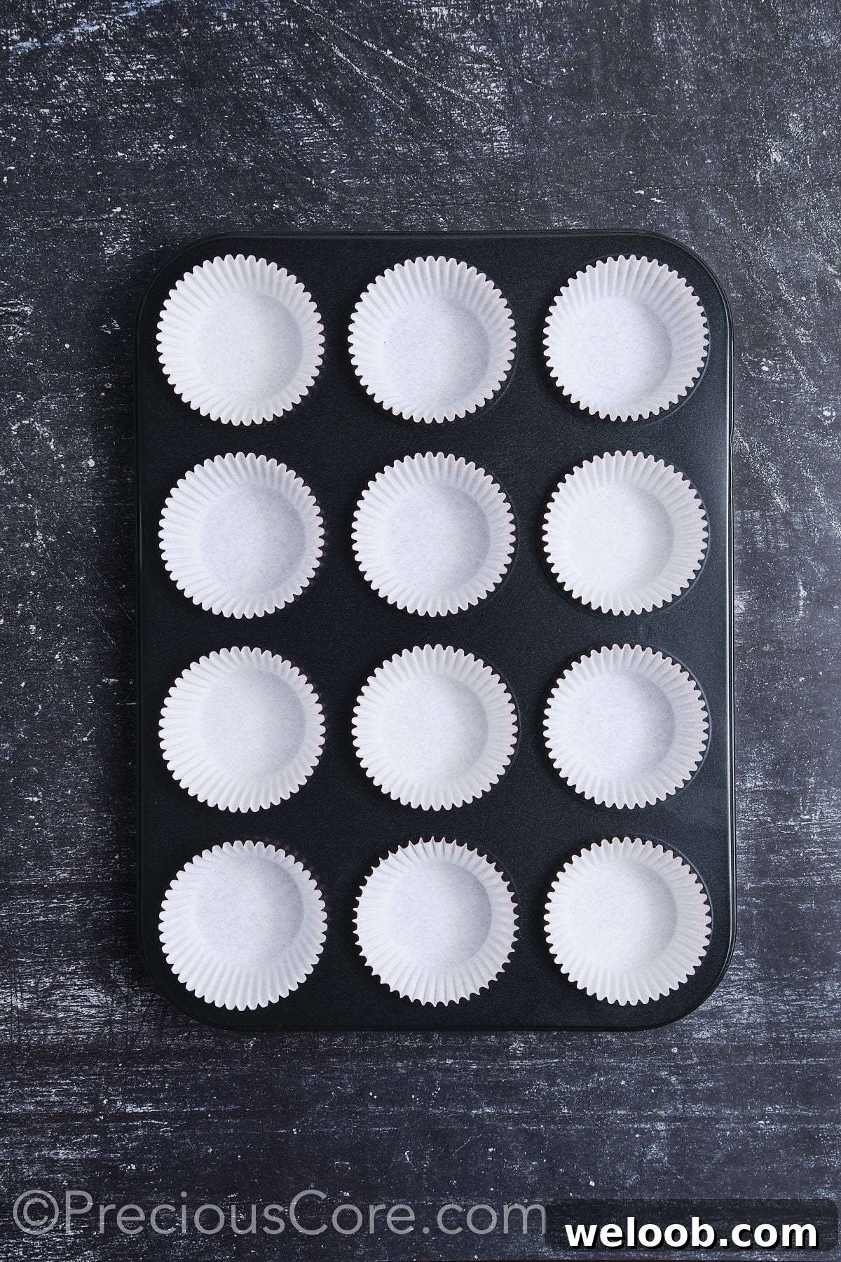 A muffin pan fully lined with cupcake liners.