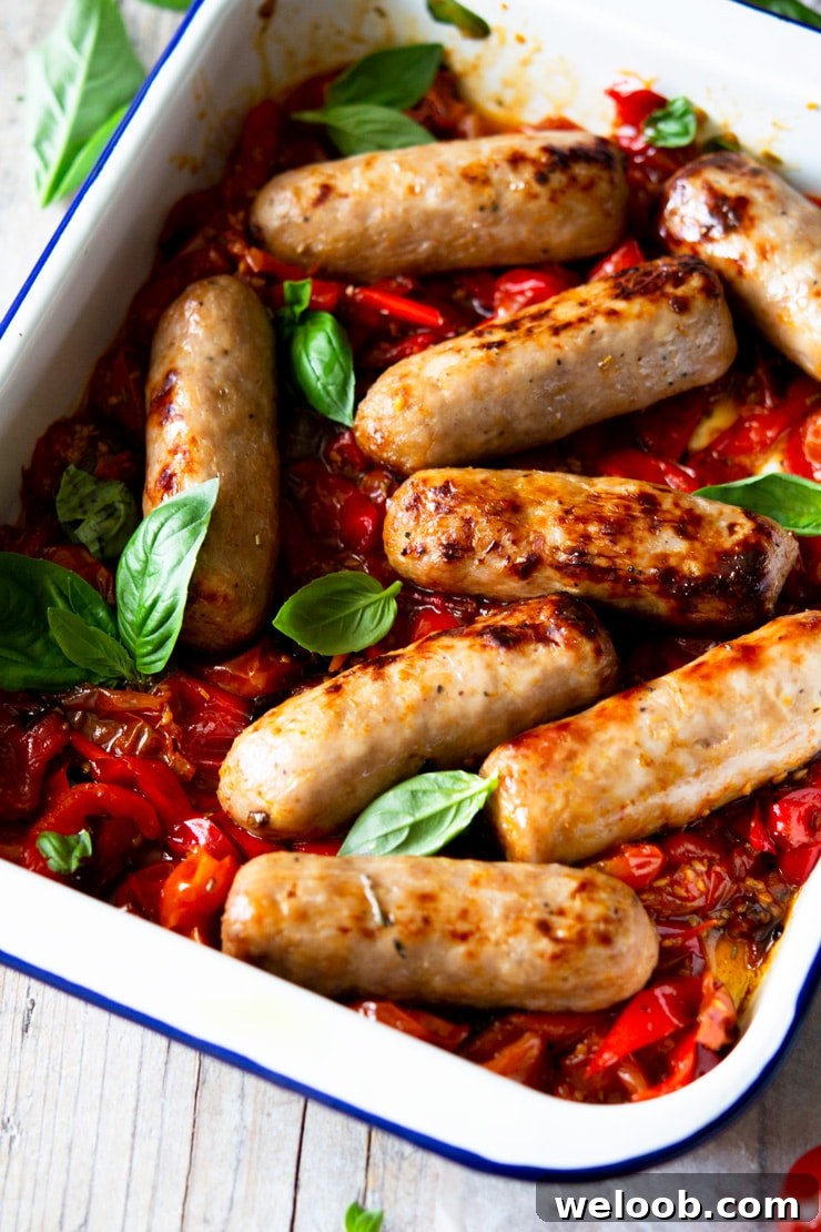 A close up of an Italian sausage bake with tomatoes and basil leaves