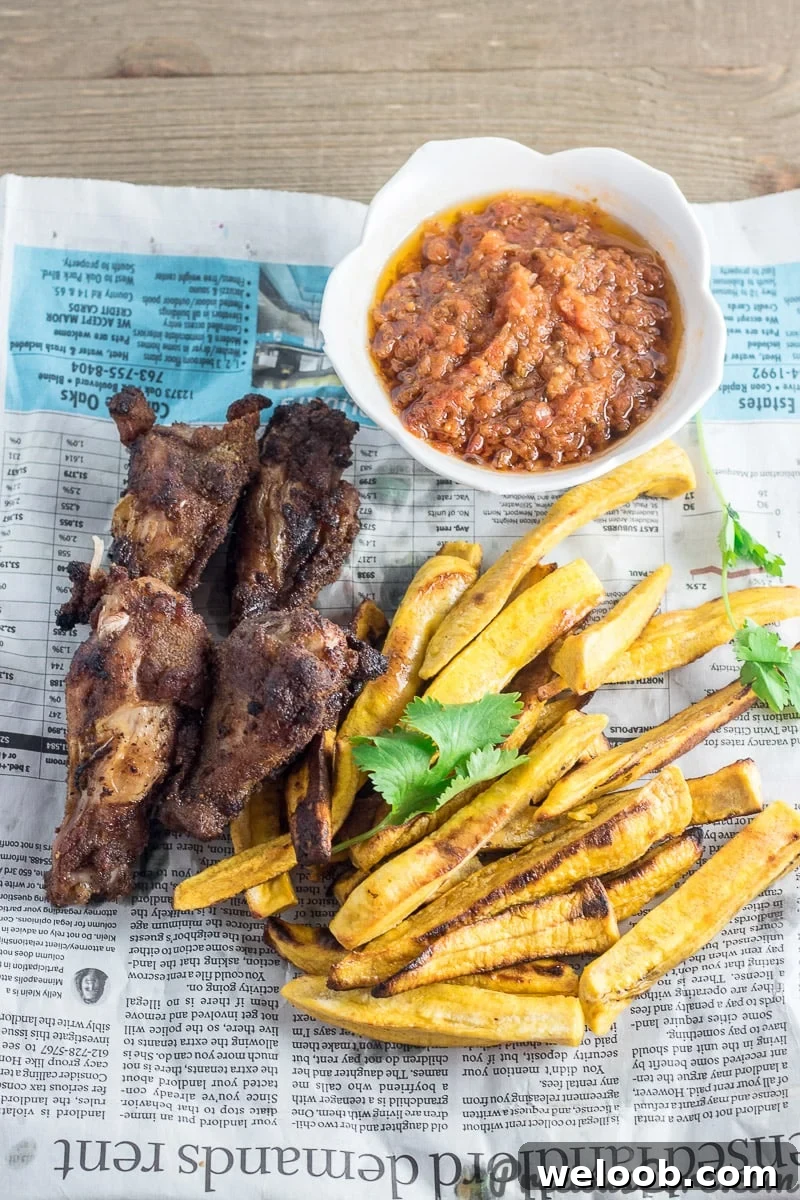 Plantains and wings on serving paper.