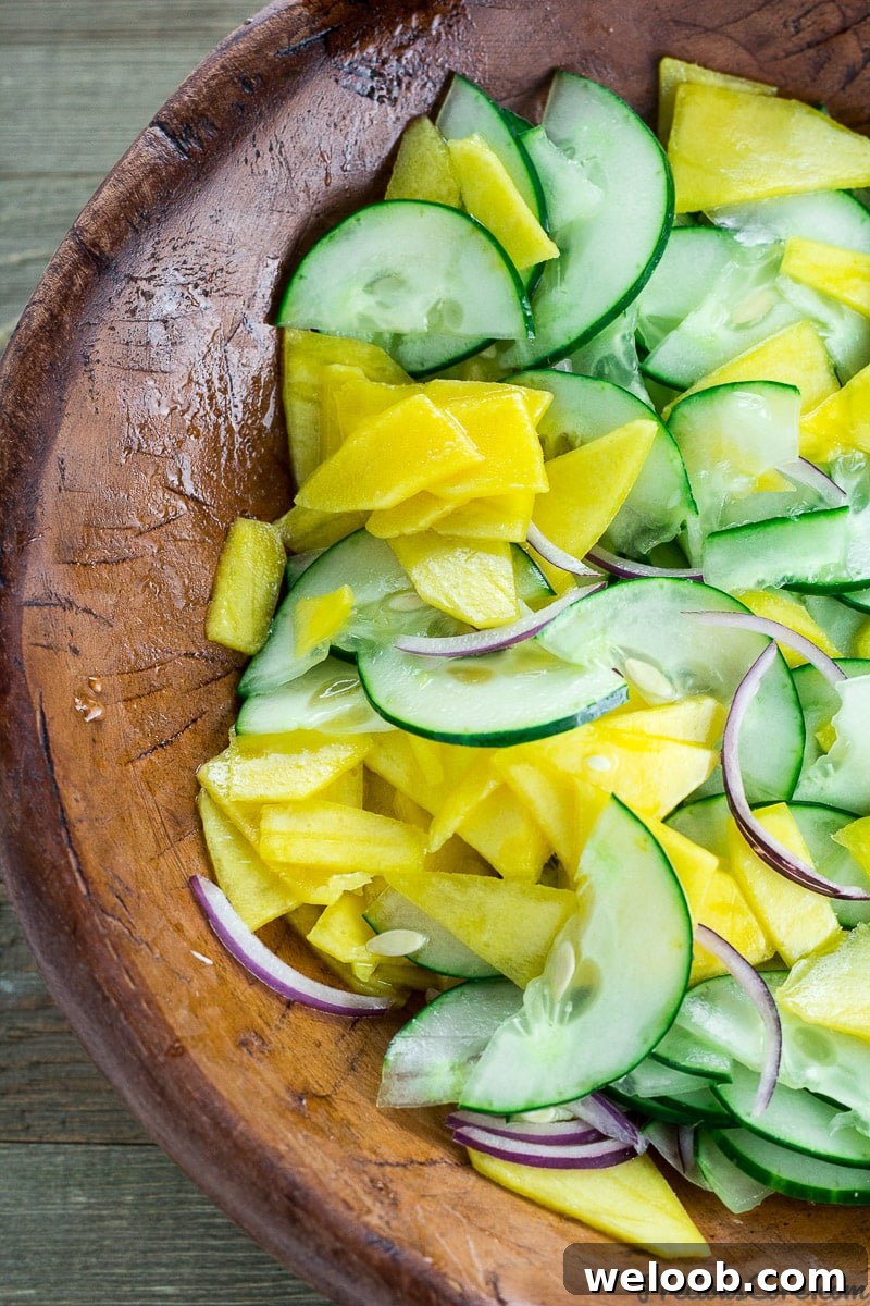 Mango cucumber salad in wooden bowl.