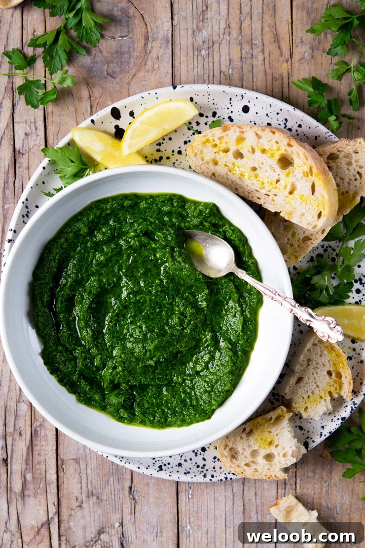 Parsley pesto in a white bowl with a spoon