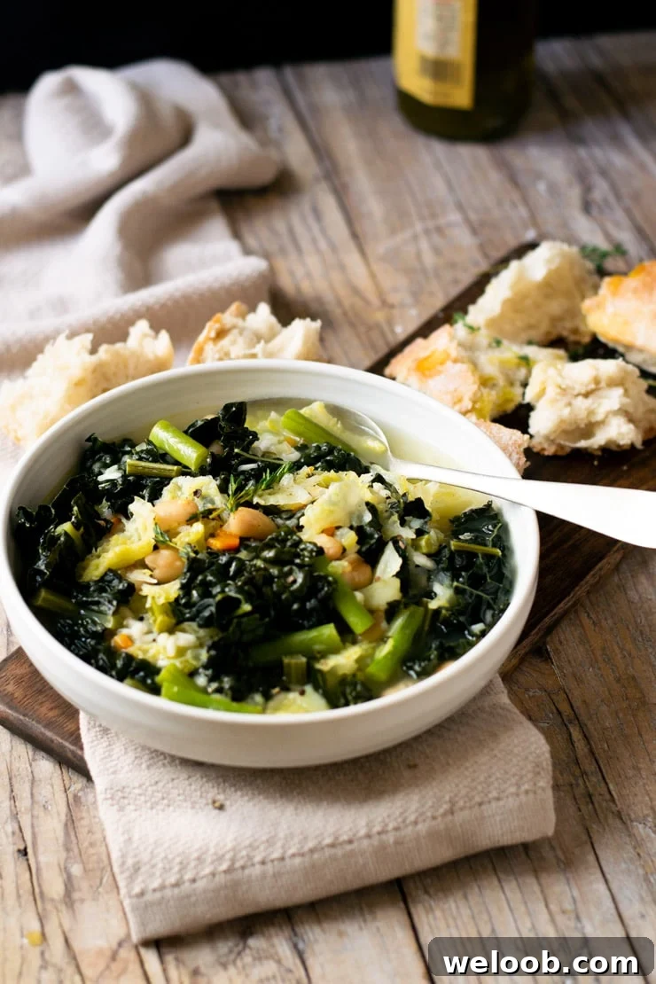 A bowl of Tuscan minestrone soup on a wooden surface with bread