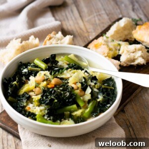 A bowl of Tuscan minestrone soup on a wooden surface with bread