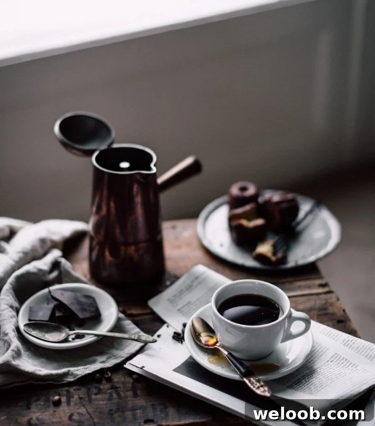 A moka pot and cup of espresso on a wooden table