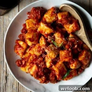 A square image of sausage ragu with ricotta gnocchi
