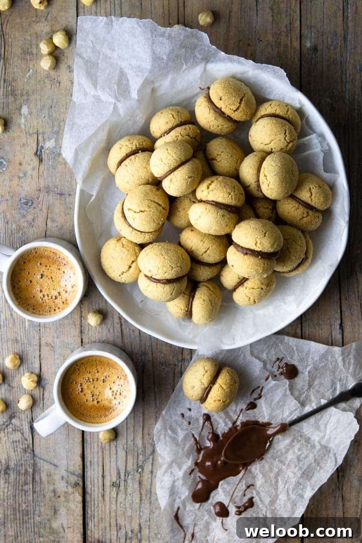 An overhead shot of lady's kisses cookies in a large bowl with coffees at the side