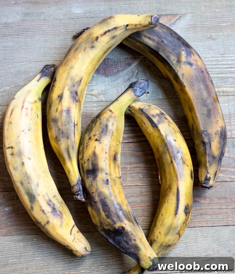 5 yellow ripe plantains on a wooden board.