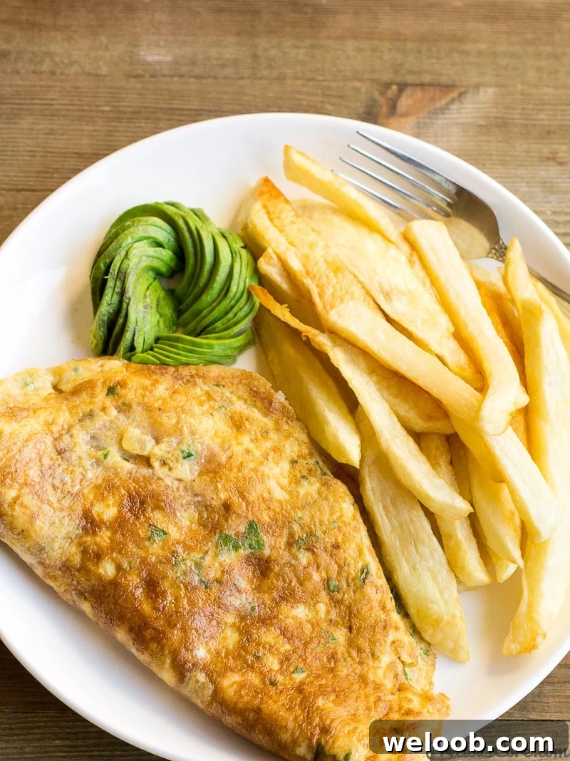 Fries and omelette for breakfast with some avocado.