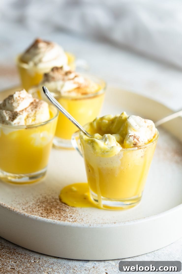 A close up of an espresso cup filled with Bombardino eggnog liqueur and spilling over the edge