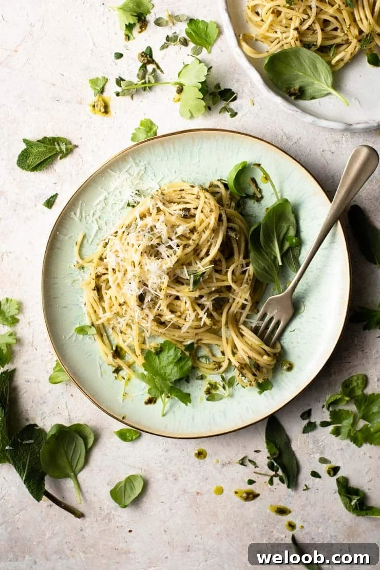 An overhead shot of spaghetti with garlic butter pasta sauce and herbs