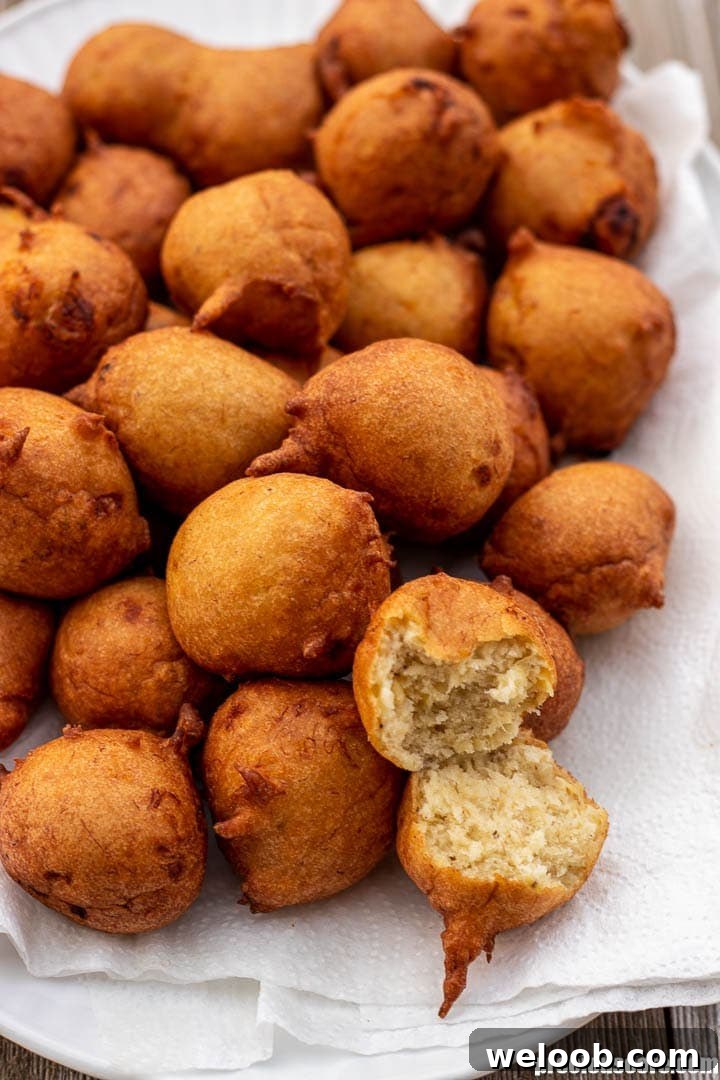Banana fritters on a platter, one opened up to show texture.