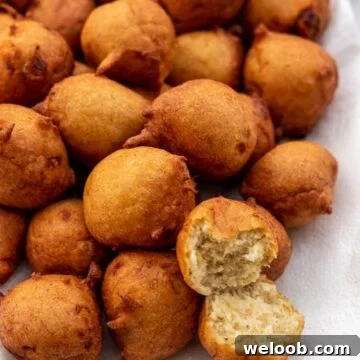 Banana fritters on a platter with one opened up to show texture