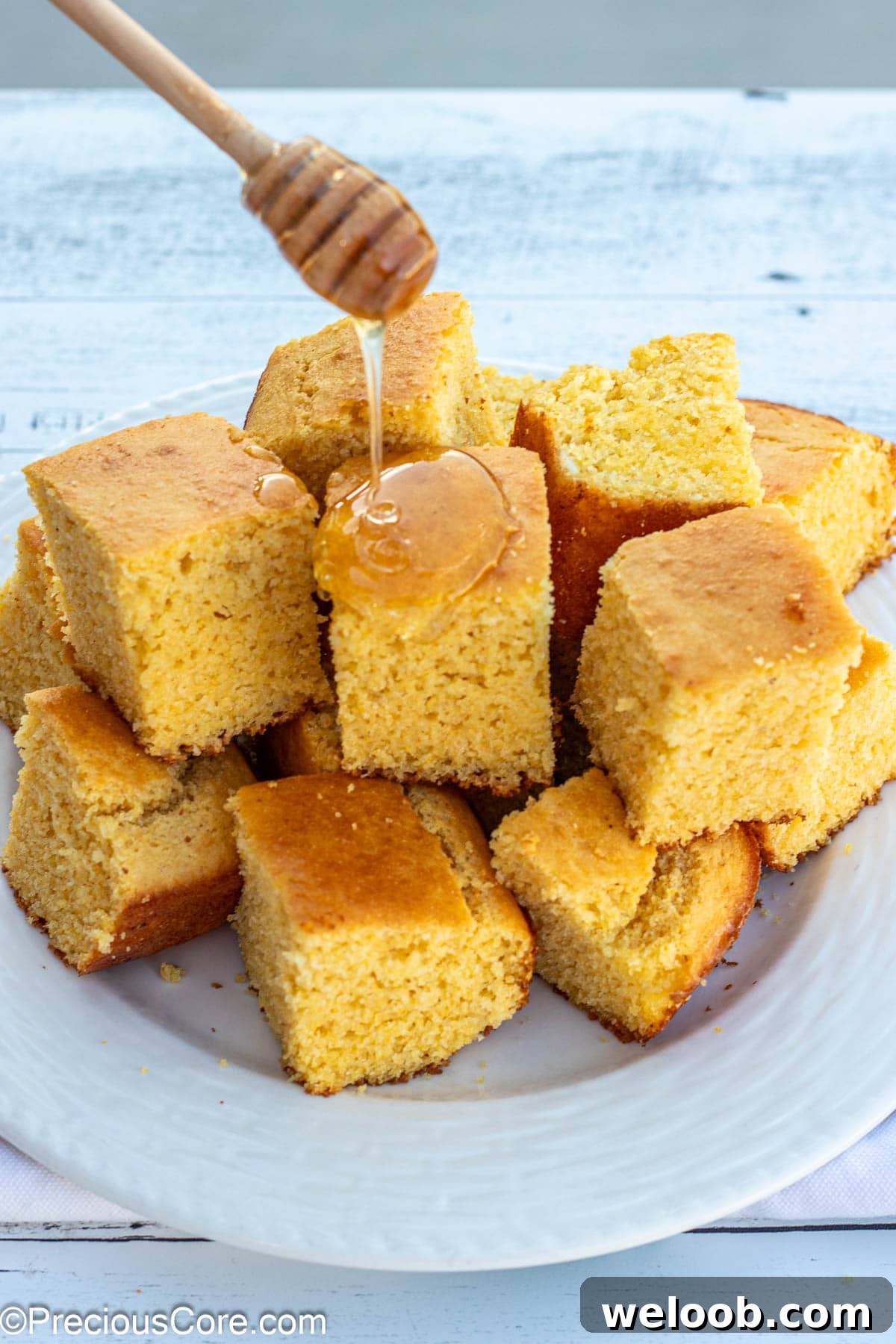 Honey wand drizzling honey on cornbread.