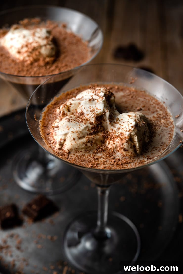 A close up of a chocolate martini topped with whipped cream and chocolate shavings