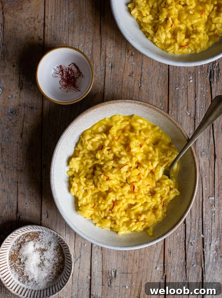 An overhead shot of a bowl of saffron risotto on a rustic wooden surface
