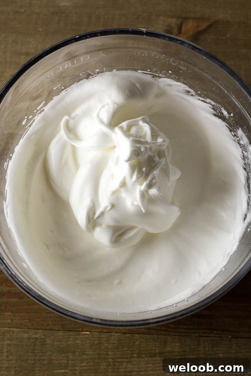 Glass bowl of whipped egg whites.