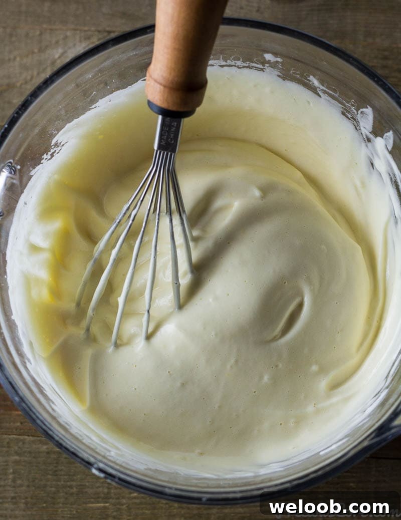 Whisk in a bowl with egg whites, vanilla, and egg yolks.