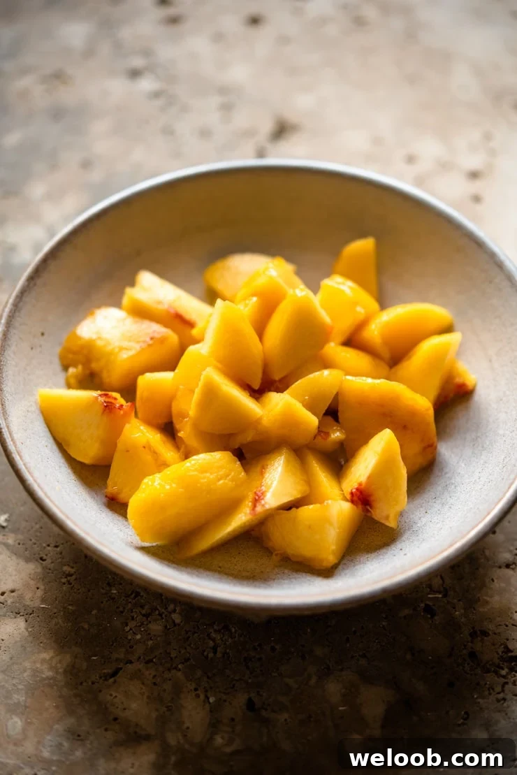 Chopped up fresh peaches in a bowl to make a peach bellini