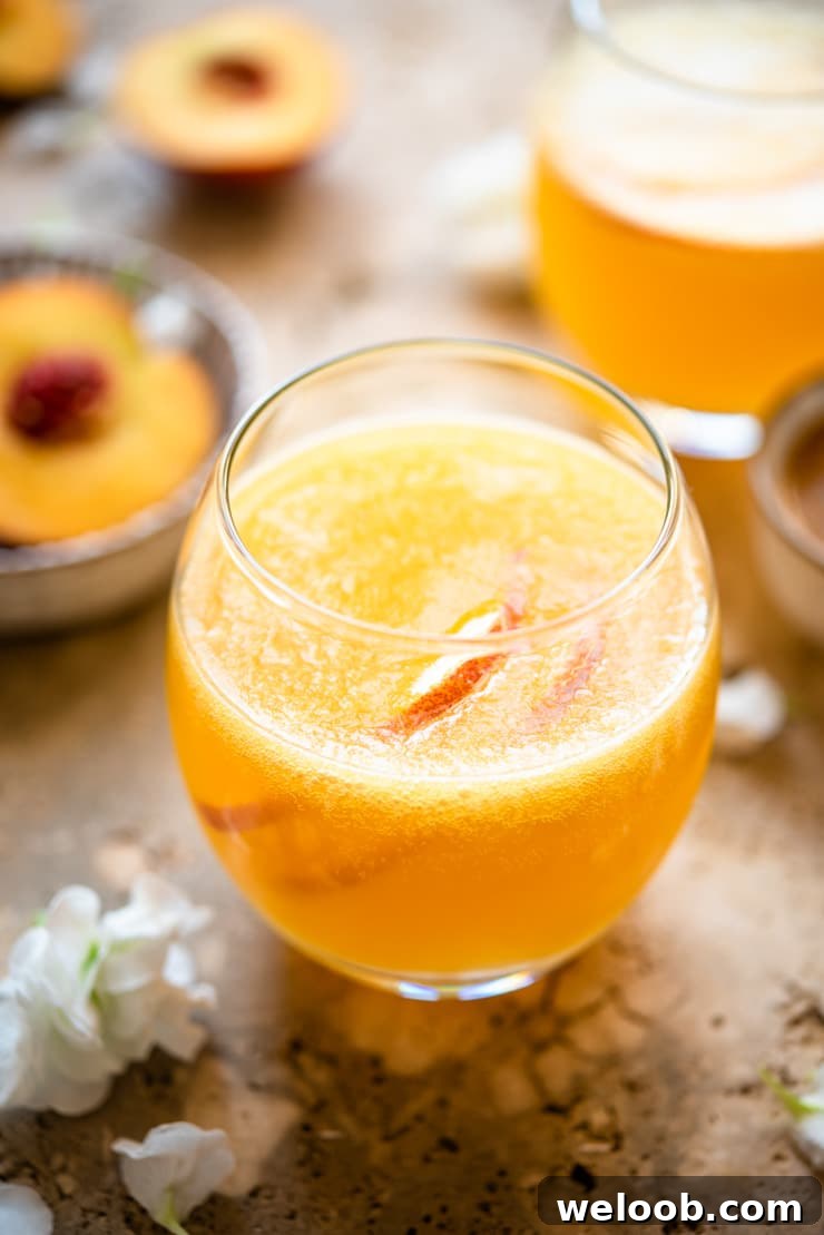A close up of a peach bellini in a round glass