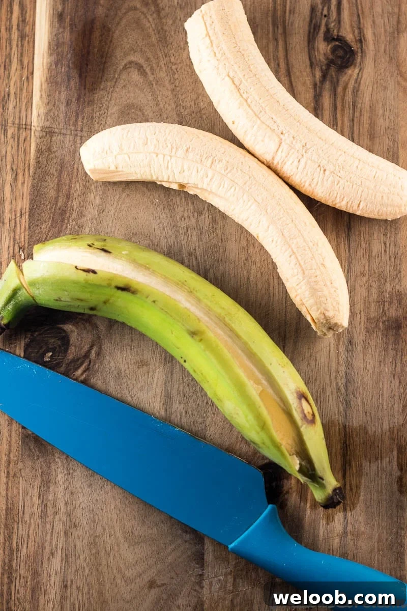 Knife with a plantain whose peel has been cut and two peeled plantains.