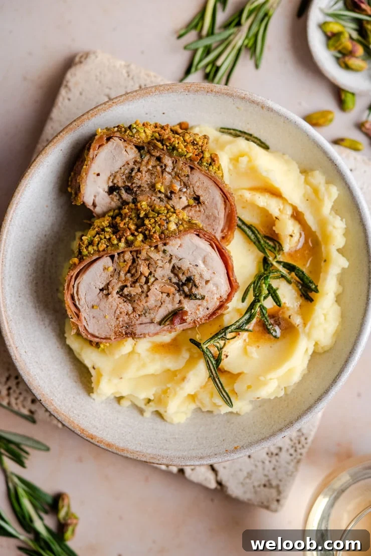 An overhead shot of stuffed pork tenderloin on top of mashed potatoes
