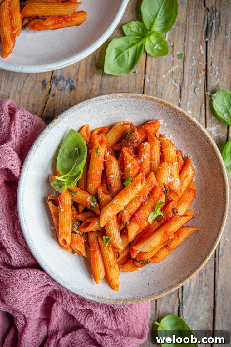 An overhead shot of tomato pasta in a bowl with basil