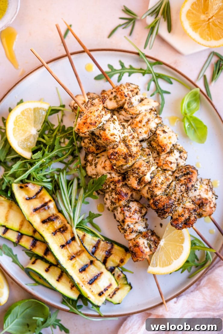An overhead shot of chicken spiedini with grilled veg and arugula at the side