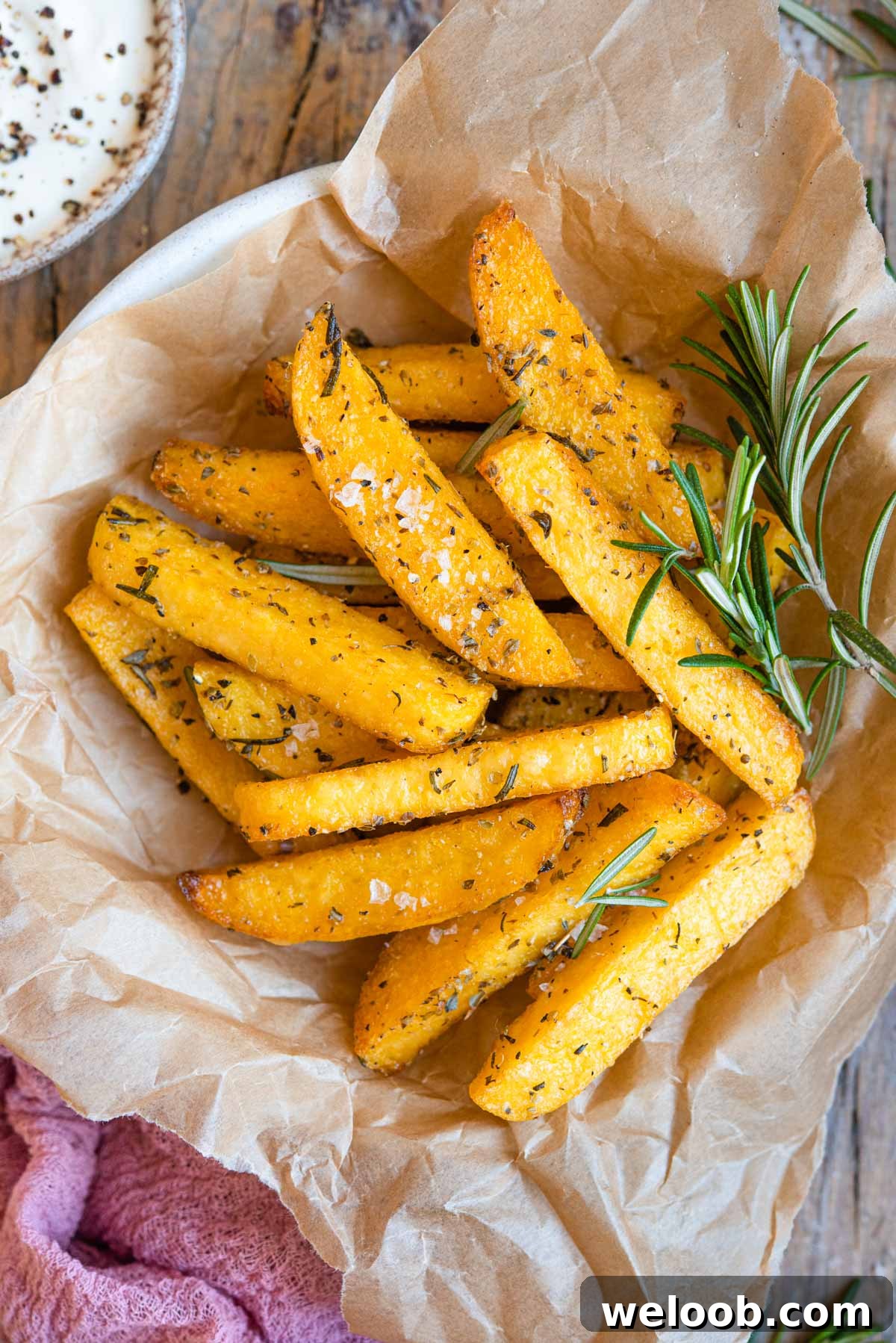 A close up of polenta cut into fries and served in a bowl with herbs
