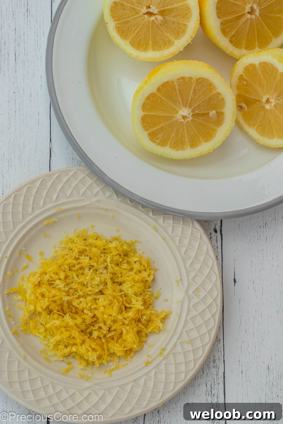 Lemon zest on one plate and lemon halves on another plate.