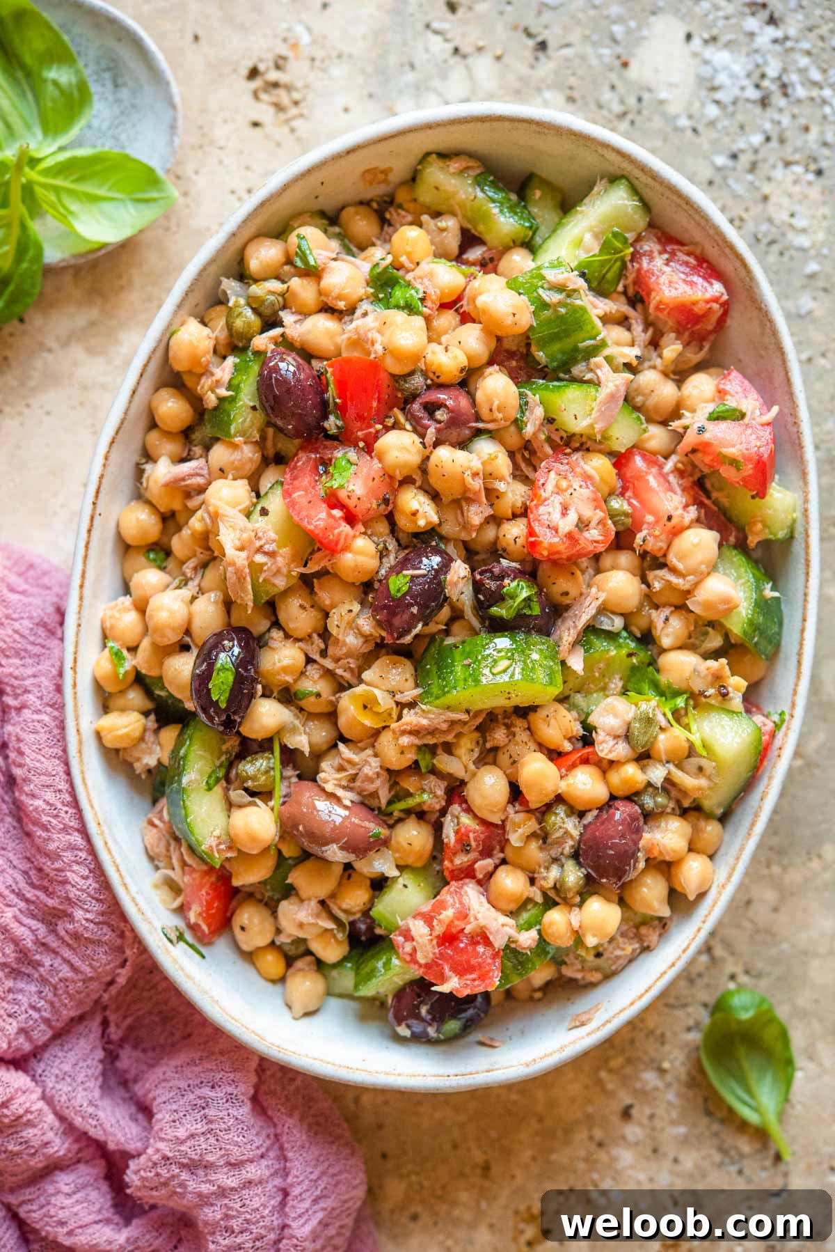 An overhead shot of a salad with chickpeas, tuna and tomatoes in a large bowl