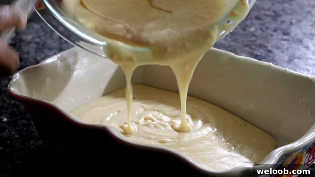 pouring batter into baking dish for South African Malva Pudding Recipe