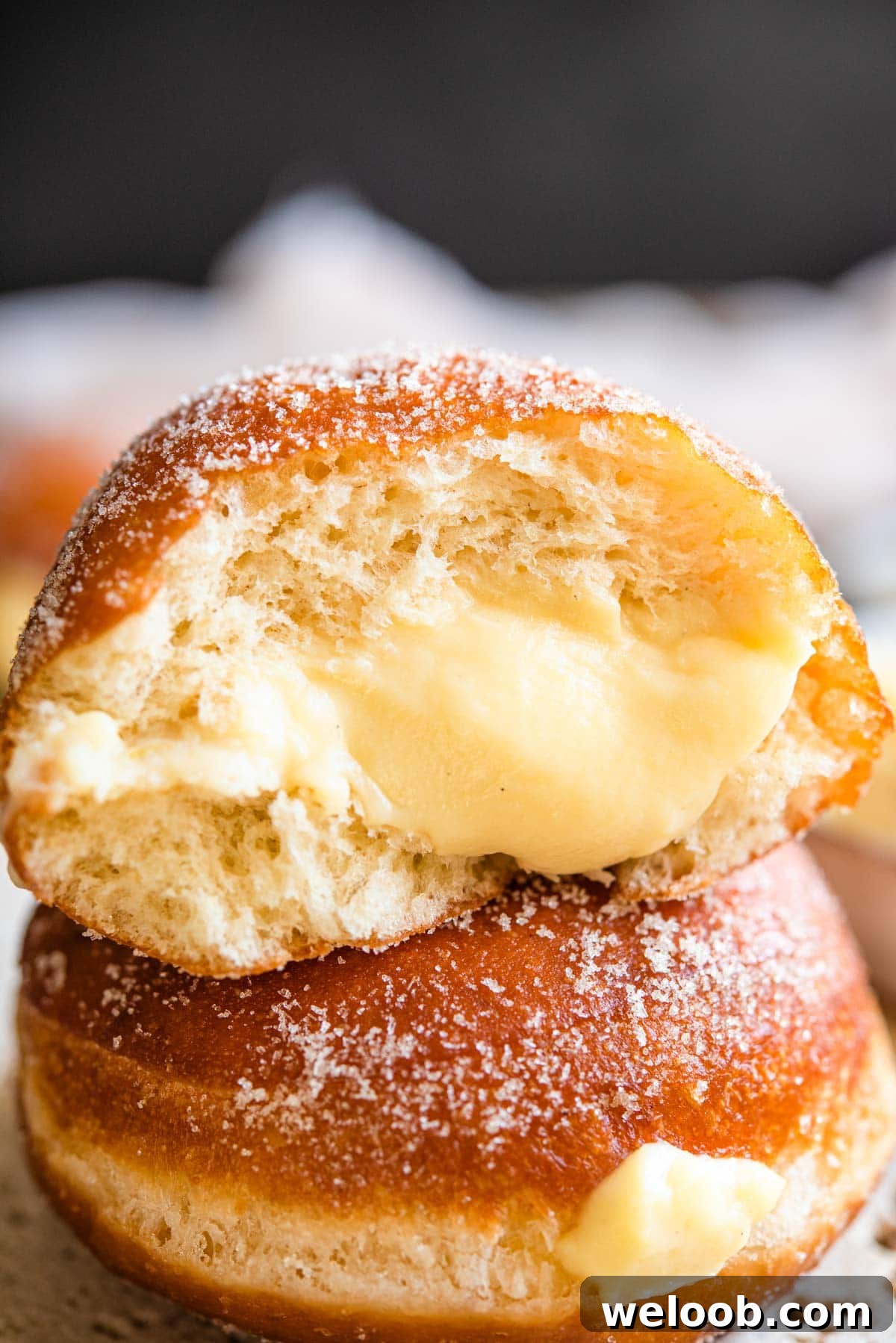 A close up of an Italian doughnut cut in half with a pastry cream filling
