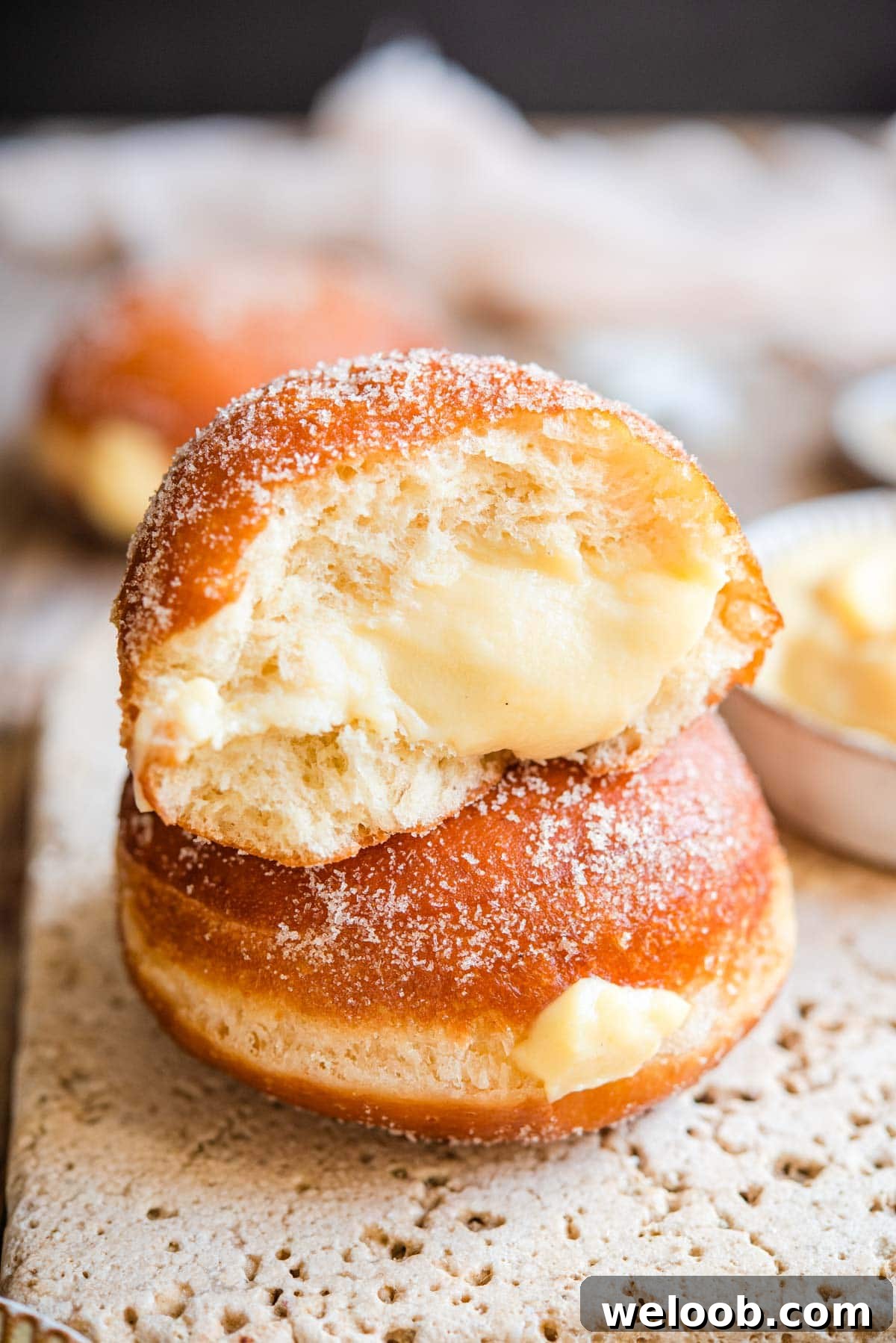 Two doughnuts stacked on top of each other with one cut in half