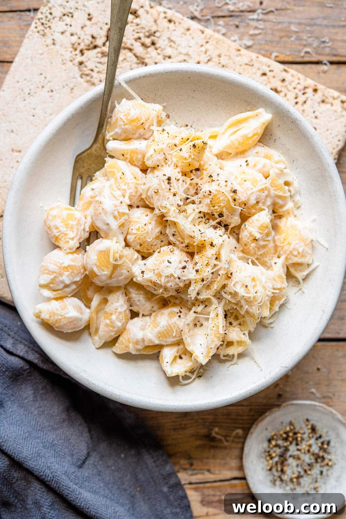 An overhead shot of ricotta pasta in a rustic bowl sitting on a wooden surface